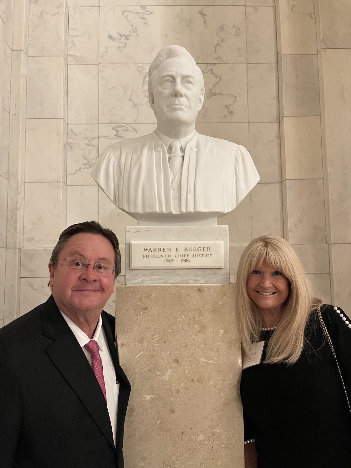 photo of chuck noteboom and his wife with a statue of warren burger