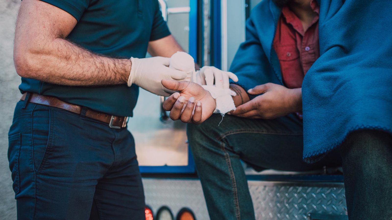 paramedic putting bandage on an arm