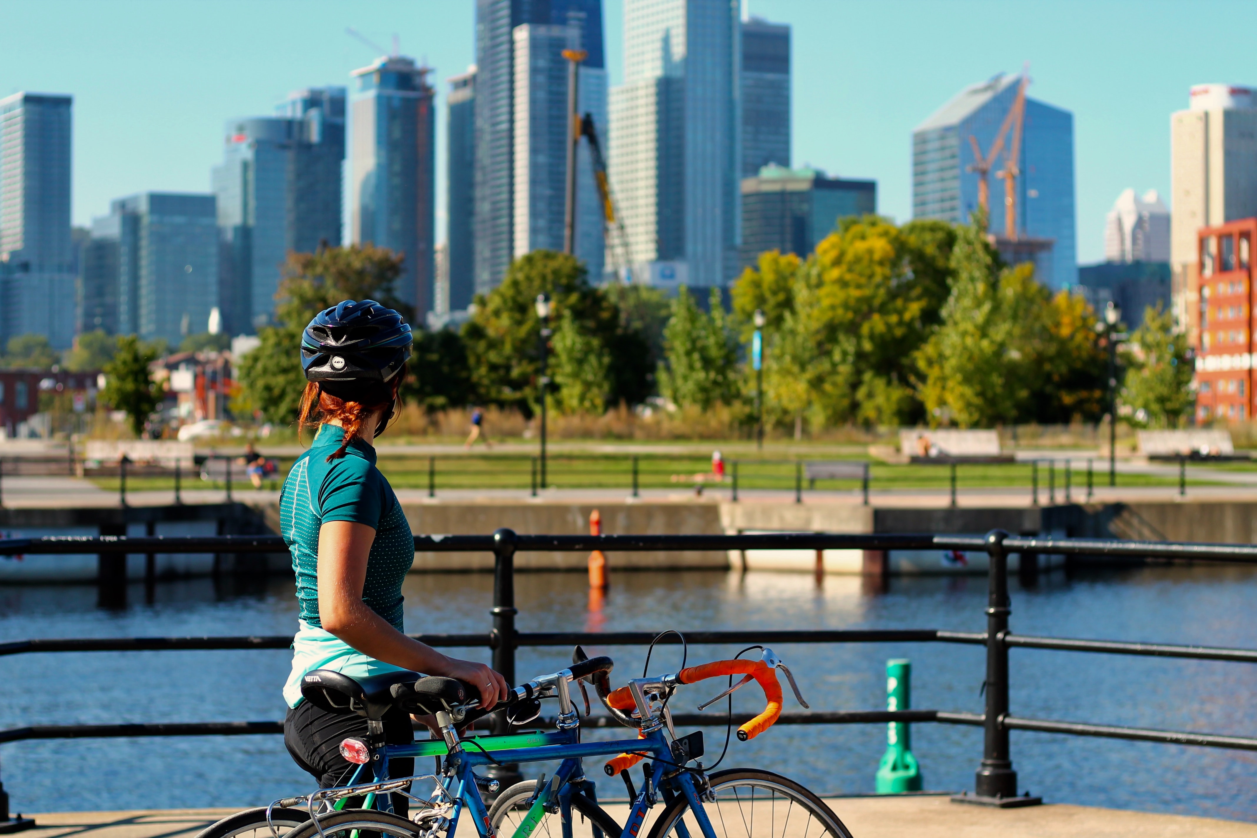 woman with bicycle overlooking city skyline
